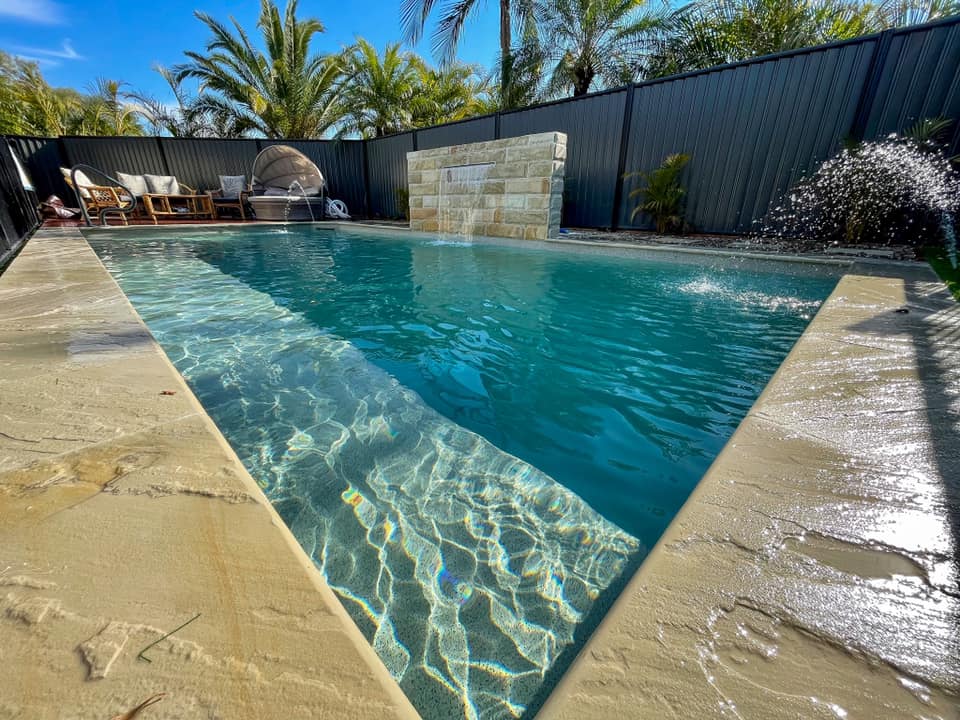 concrete inground pool with water feature